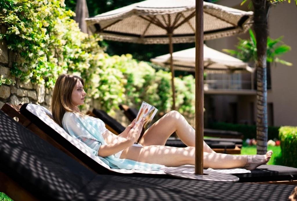 Select Hill Resort a woman lying on a lounge chair reading a magazine