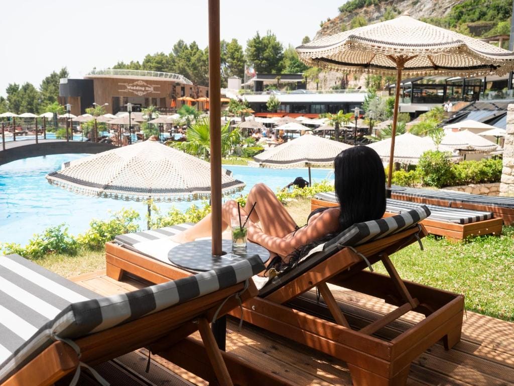 Select Hill Resort a woman sitting on a lounge chair by a pool
