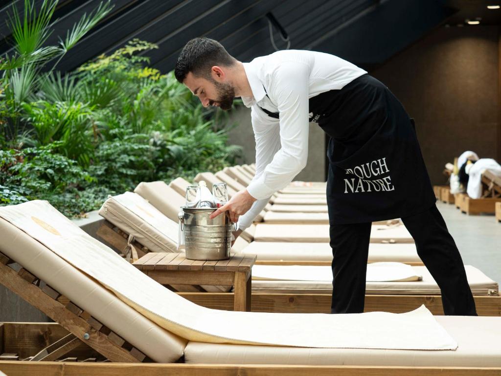 Select Hill Resort a man in an apron and apron standing next to a table with chairs