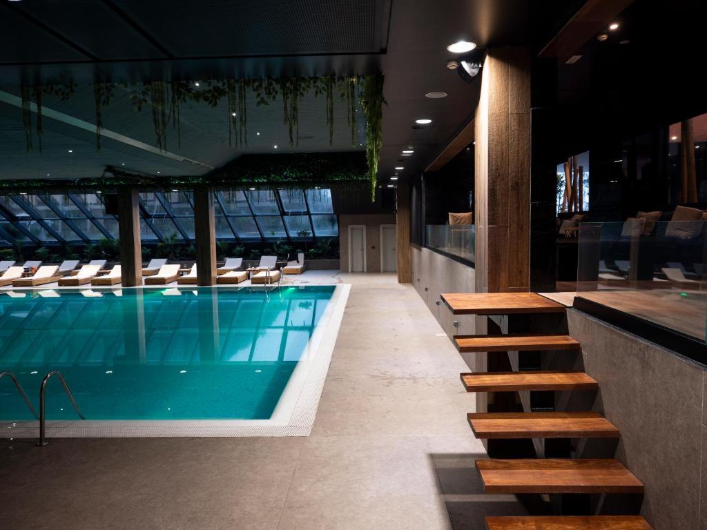 Select Hill Resort a pool with a staircase and a glass wall